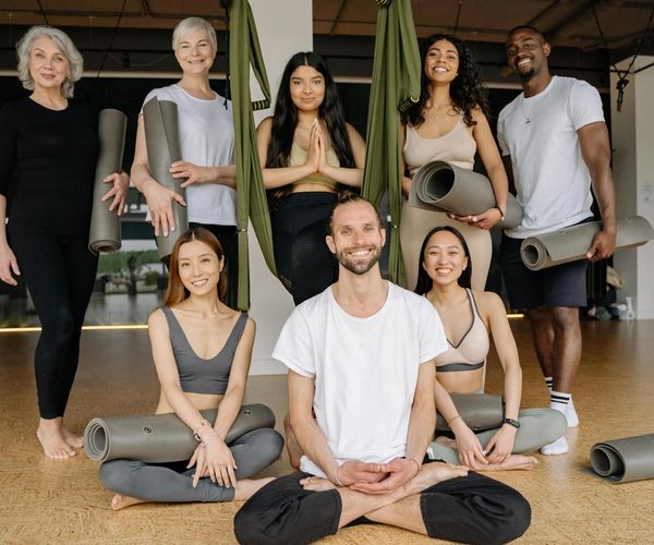 Diverse group of people of different ages smiling during a yoga class.