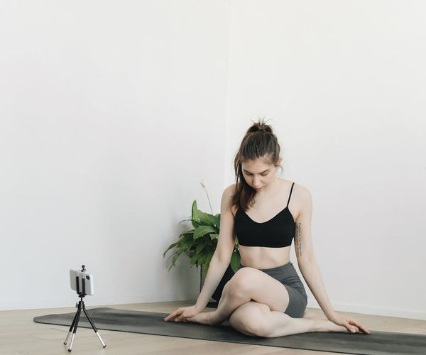 Person stretching on a yoga mat with a look of peaceful satisfaction.
